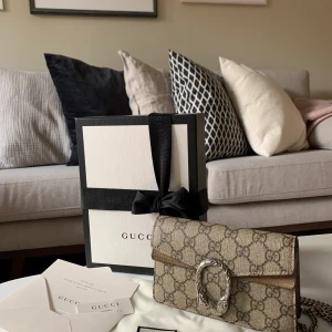 Gucci Dionysus - Säljer min fantastiska Gucci Dionysus GG Supreme super mini bag, pga att jag inte längre använder den. Inköpt på gucci.com 2019 och har används med stor försiktighet. Mycket fint skick både utvändigt och invändigt. Går att använda både som crossbody, på axeln och som clutch. Kvitto, orginalkartong, dustbag, ”kontrolllapp” mm medföljer självklart. Nypris 6900 kr. Vid intresse skickar jag gärna fler bilder osv.