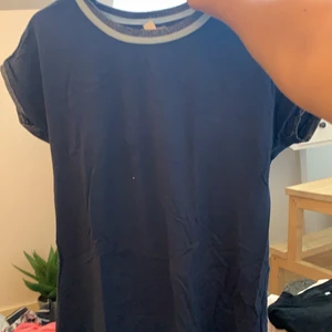 En tröja  - Här är en blå tröja med grå blått i kanten längst upp 