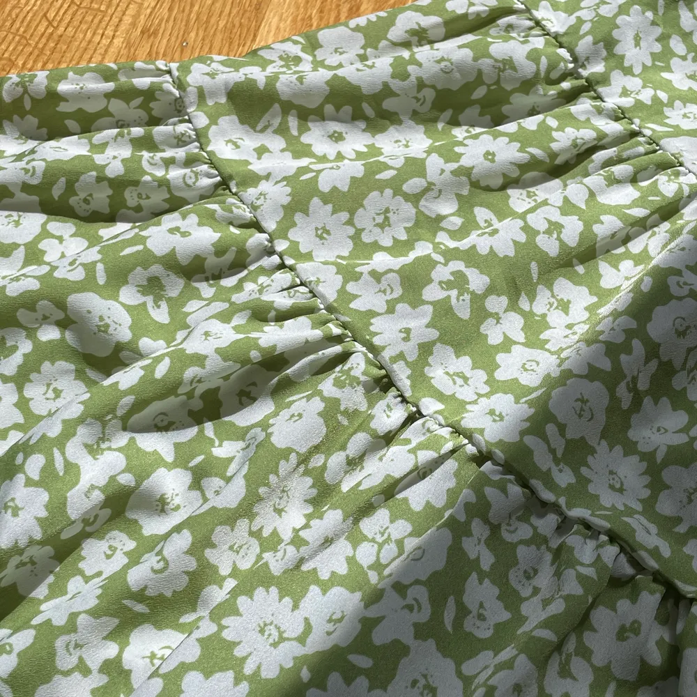 En super super vacker grön sommar klänning men blommor på. Spänn in bara axelband och dragkedja på ryggen som finns på bild två. För att se hur tyget ser ut bläddra till bild tre!! Använd 4 ggr! Frakt 45kr💚. Klänningar.