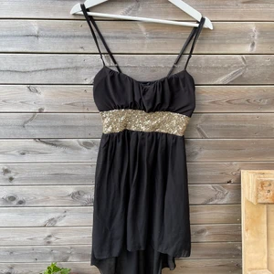 Svartklänning med paljetter - Fin svartklänning med paljetter och justerbara band. Är kort framtill och längre baktill. Passar S/M 