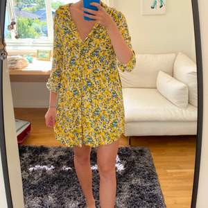Jättefin gul och blå blommig skjortklänning från Samsoe Samsoe! Jag är ca 175 cm och klänningen slutar en bit över knäna på mig!