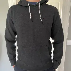 Säljer en mörkgrå Tommy Hilfiger hoodie i storlek M. Använd flertal gånger men väl skick. Nypris 800kr. Köparen står för frakt.