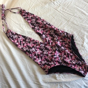 Baddräkt Na-kd - Blommig baddräkt från Na-kd med djup rygg och mycket v-ringning framtill. Helt oanvänd och med fin knytdetalj vid nacken. Köparen står för frakt. 