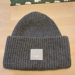 Acne mössa  - Säljer grå acne mössa, knappt använd så i nyskick! Kan givetvis tvätta den innan jag skickar om det önskas. Äkta, finns kvitto. 