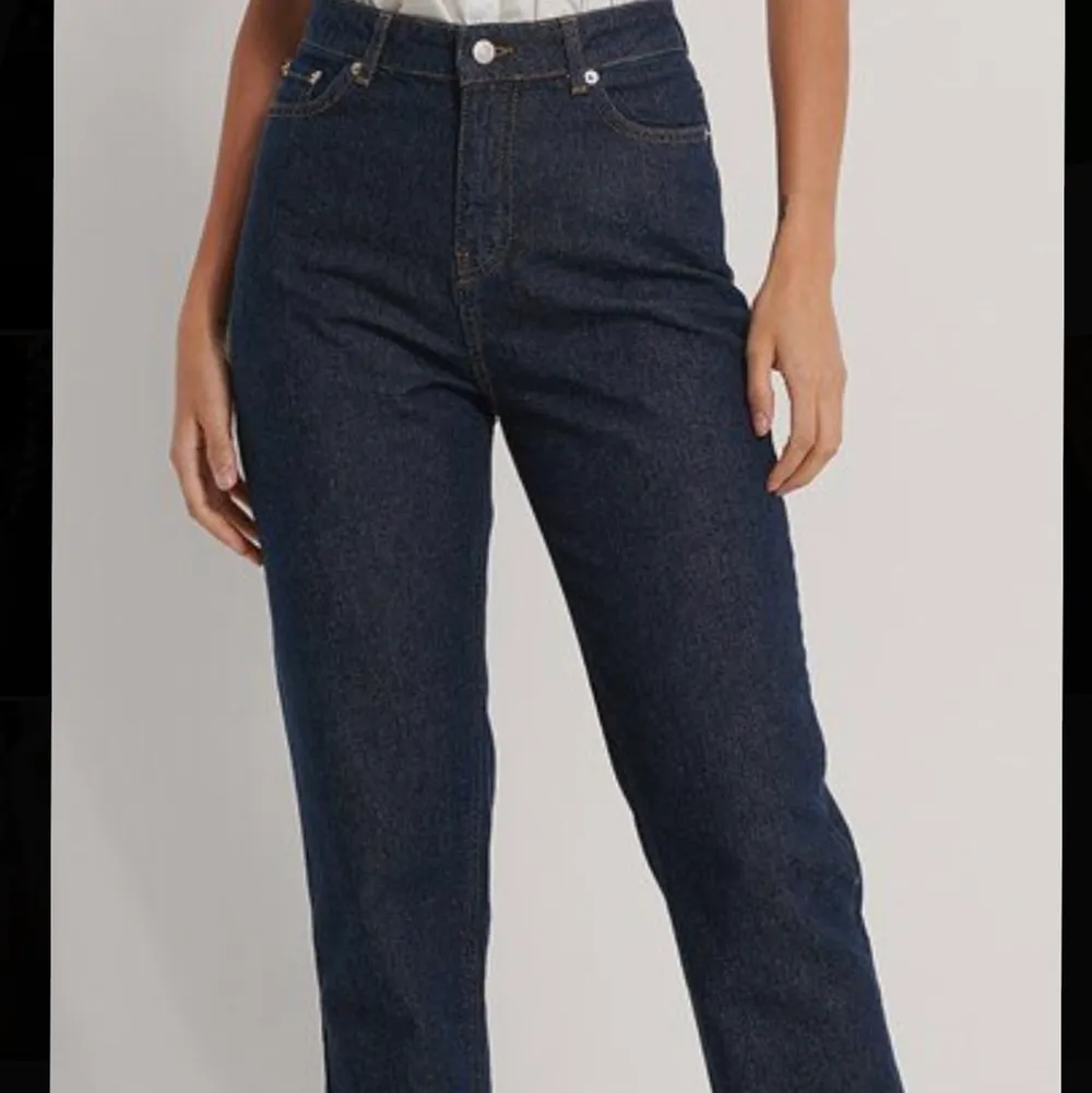 Mörkblåa jeans från NA-KD, knappt använda. Högmidjade och en slits nere på benen. Köpare står för frakt:). Jeans & Byxor.