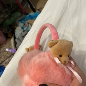 Öron värmare/öronmuffar - Hej! Jag säljer mina söta öronmuffar då dom inte kommer till användning. Dom är väldigt söta och har rosa fake päls på sig och två söta nallebjörnar med rosett åt sidorna. Den är för vuxna men funkar även för barn och du kan justera det till din storlek (oanvända)  GÅR ATT DISKUTERA PRISET