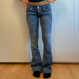 Lågmidjade Jeans Flare - Blåa low waisted jeans i flare/bootcut. Märket är Twenty Easy. Jag är 168 cm för referens. De har en liten slitning på vänstra ben vilket man ser på andra bilden💓