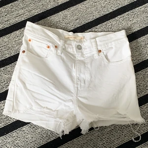 Vita Levis shorts  - Vita high rise Levis shorts i stolen 26. Knappt använda i gott skick😆💋 slitningar längstner på framsidan av benet💜💜 köparen står för frakt⚡️