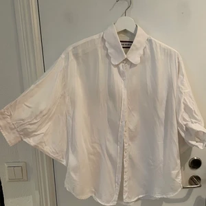 The Shirt Factory blus - Blus/skjorta från The Shirt Factory med vida ärmar som synes på bilden! Speciell stil, löst sittande och bekväm.