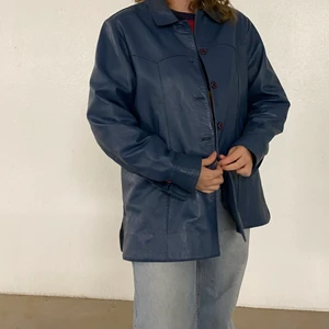 Blå skinjacka - Superfin blå skinnjacka med mörklila knappar köpt på secondhand för någon vår sedan! Liten skada vid vristen i ena ärmen men inget som syns när man har på sig jackan.