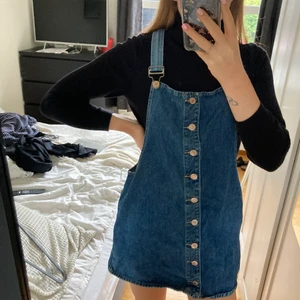 Jeans klänning - Jeansklänning med hängslen i bred model men fickor, använd fåtalet gånger💛 Väldigt liten i storleken, står L men skulle säga att passformen är med för xs/s 