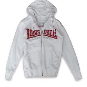 Supernsnygg vit vintage Lonsdale zip up hoodie i storlek XS. Den är i bra skick.  Så snyggt med låga jeans😍