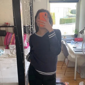 Marinblå tröja - En fin marinblå tjocktröja som inte kommer till användning. Köpt på Erikshjälpen i bra skick och använd sparsamt. Den har vita linjer både i krakes och långa ut på armar och nederdelen av tröjan. Jättefin att matcha till vita jeans eller en höstlook men kjol och tajts. Materialet är ribbat och är i storlek 38-40. Den sitter lite oversized på mig och skulle säga att den är true to size. Frakt tillkommer och pris kan diskuteras. 