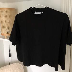 En jättefin svart vid, något croppad t-Shirt från Weekday i storlek S. Knappt använd och i jättefint skick!
