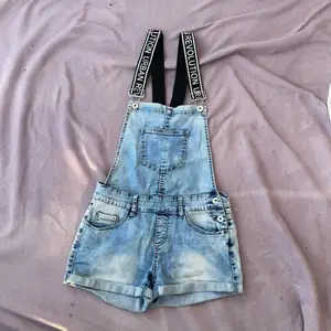 Ljusblå jeans shorts overall från FB sister. Svarta band med vit text på, fickor och silver knappar💕👍🏻