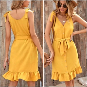 Gul klänning S/36 volang knappar band NY - Färg: gul.  Strl: S/36.  Skick: nyskick, förvarad i påse.   Fin sommrig klänning, med knappar framtill och medföljande knytband i midjan. Axelbanden går att knyta och ändra längd på. Går att regler på flera vis. Volangkant nedtill. Aldrig använd, helt ny! Betalning via swish, frakt tillkommer.