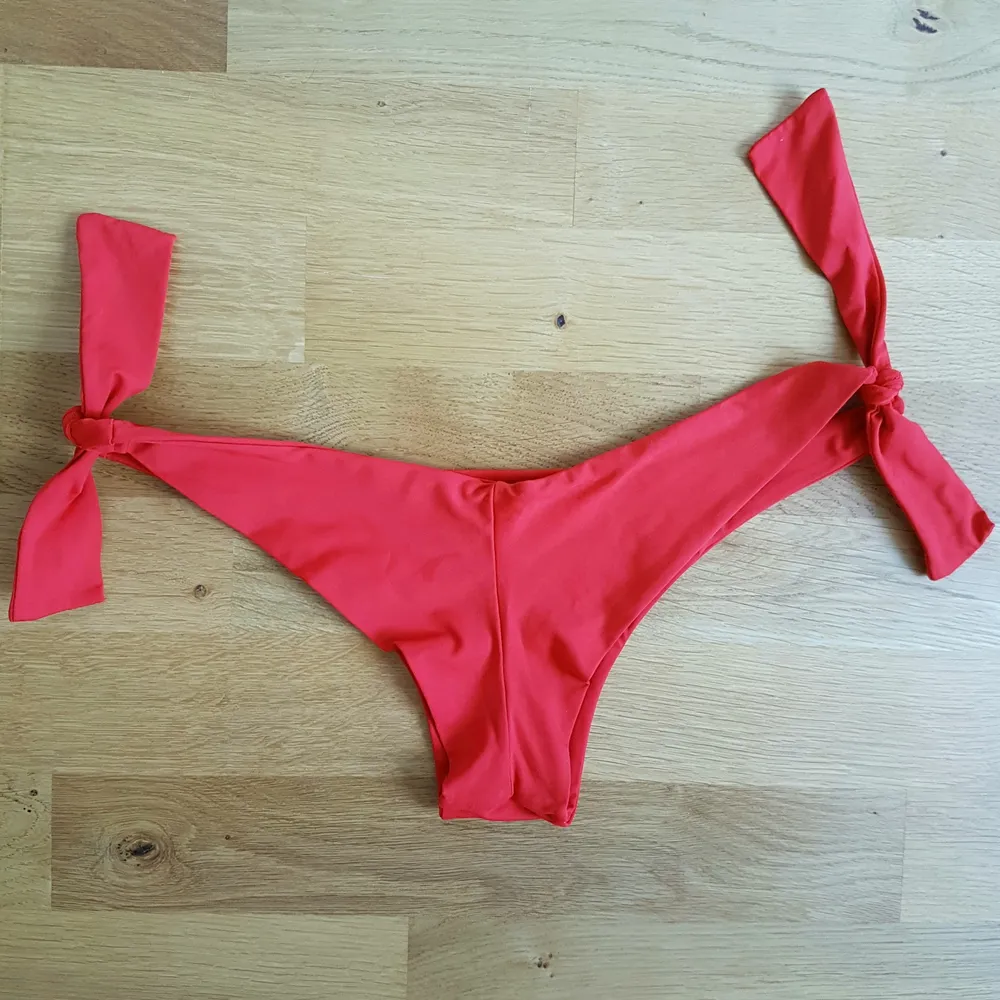 Snygg, röd, brasilian bikiniunderdel med knytning på båda sidorna, passar stl: XS-S. Stil halvstring.. Övrigt.