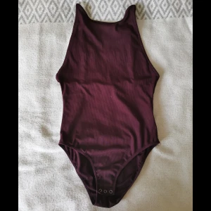 Body med öppen rygg - Elastisk, skön body från BikBok. Mycket fint skick, knappt använd. 