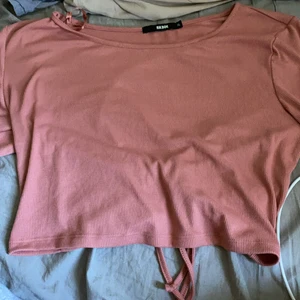 Bikbok  - En rosa topp med en lång snöre vid ryggen ,oandvänd  