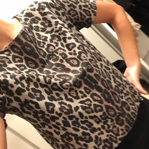 Topp i leopsrdmönster - Cool topp i leopardmönstrat med små glitterkorn i tyget. Storlek S och aldrig använd. 