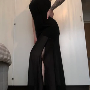 maxiklänning med slits - svart långklänning med slits i båda sidorna, skönt material, snygg detalj i ryggen, lite svår att fota men det är tight i midjan (med stretch) men annars flowig🌺 är 168cm och klänningen slutar typ 2cm ovanför marken för mig :)