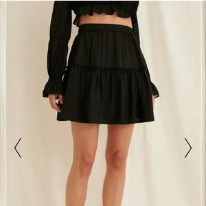 Svart Minikjol stl 36 - Superfin enkel sommarkjol från NA-KD!  Det är en kort resor i midjan samt en stor volang ned till som du kan se på bilden. Säljer på grund utav att den blivit för liten för mig. Använd ett par gånger förra sommaren🖤originalpris: 349kr mitt pris: 100kr + frakt