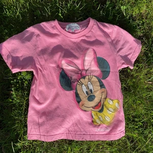 VINTAGE DISNEY PINK BABY TEE - Säljer en vintage rosa Disney crop top/baby tee. Originell från Disney Hong Kong! Är i bra kondition, dock ett mindre hål på baksidan. PERFEKT FÖR SOMMAREN!!!!😍😍😍 Y2K DRÖM. 15% RABATT VID KÖP AV FLERA PRODUKTER