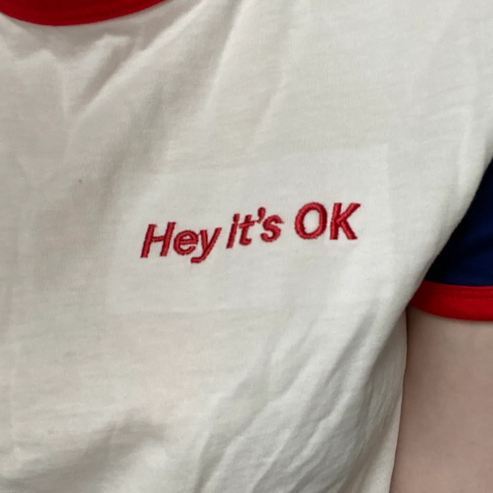 En vit tröja från Monki med texten ”Hey it’s OK”. Aldrig använd. Frakt 45 kr 🌿 Finns i Västerås! . T-shirts.