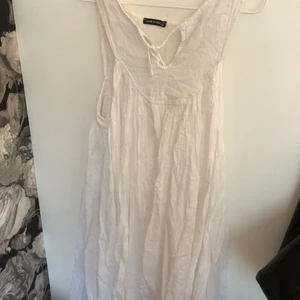 Vit klänning - Vit klänning i ganska tunt material med en liten knytning framtill. Använt ett fåtal gånger, fint skick! Perfekt till sommaren! Köpt utomlands:) 