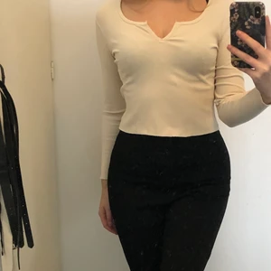 Beige topp - Topp från Gina tricot i beige med snygg detalj i fram . Köparen står för frakten.