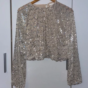 Glittrig topp - Glittrig topp från H&M. ✨ Storlek M. Passar även en S. Endast använd en gång. Säljer för 150kr + frakt. Betalning sker via swish. 