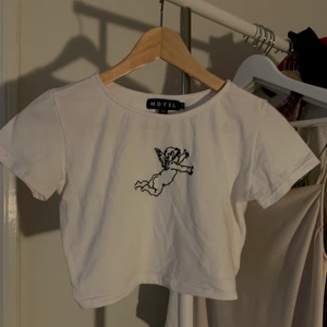Croptop med ängel - Fin croptop från Motelrocks med änglatryck! Passar XS/S, säljes för 100 kronor exklusive frakt 🌞