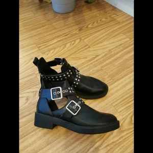 Svarta boots med nitar - Snygga svarta boots med cut outs och nitar från HM. Storlek 35. Aldrig använda. Köparen står för frakten, men vet inte exakt kostnad nu. 