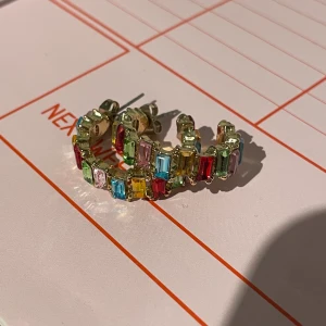 Örhängen  - Multifärgade örhängen med guld på baksidan. Köpte på glitter har haft dom 1 gång. Som nya! 