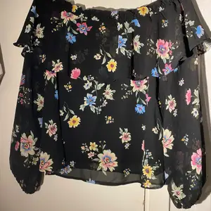 En super snygg off shoulder-blus i storleken M. En blus i skir, vävd kvalitet med krinklad effekt. Den har axlar samt resår och bred volang upptill. Blusen har används en gång sen köpet. Funkar perfekt på sommaren tillsammans med jeans shorts. FRAKT INGÅR💞