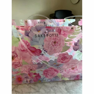 SAKS POTTS blommig väska plast rosa - SAKS POTTS blommig väska i plast. Oanvänd av mig, köpt på Vestiaire Collective för 800kr + frakt. Har små, små märken efter användning men syns knappt! Fler bilder finns.