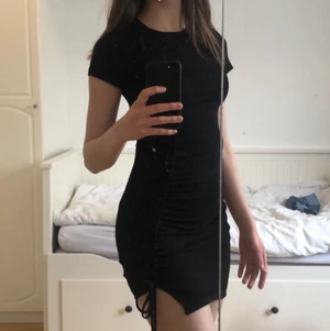 Räfflad figurnära klänning fr H&M - Svart klänning som använts endast två gånger. Man kan justera längden på klänningen genom att dra i banden längst ner i kanten. Det ger även klänningen en lite ”räfflad” look. Materialet är tunt och stretchigt. Köpare betalar frakt. Kan mötas i Stockholm<3