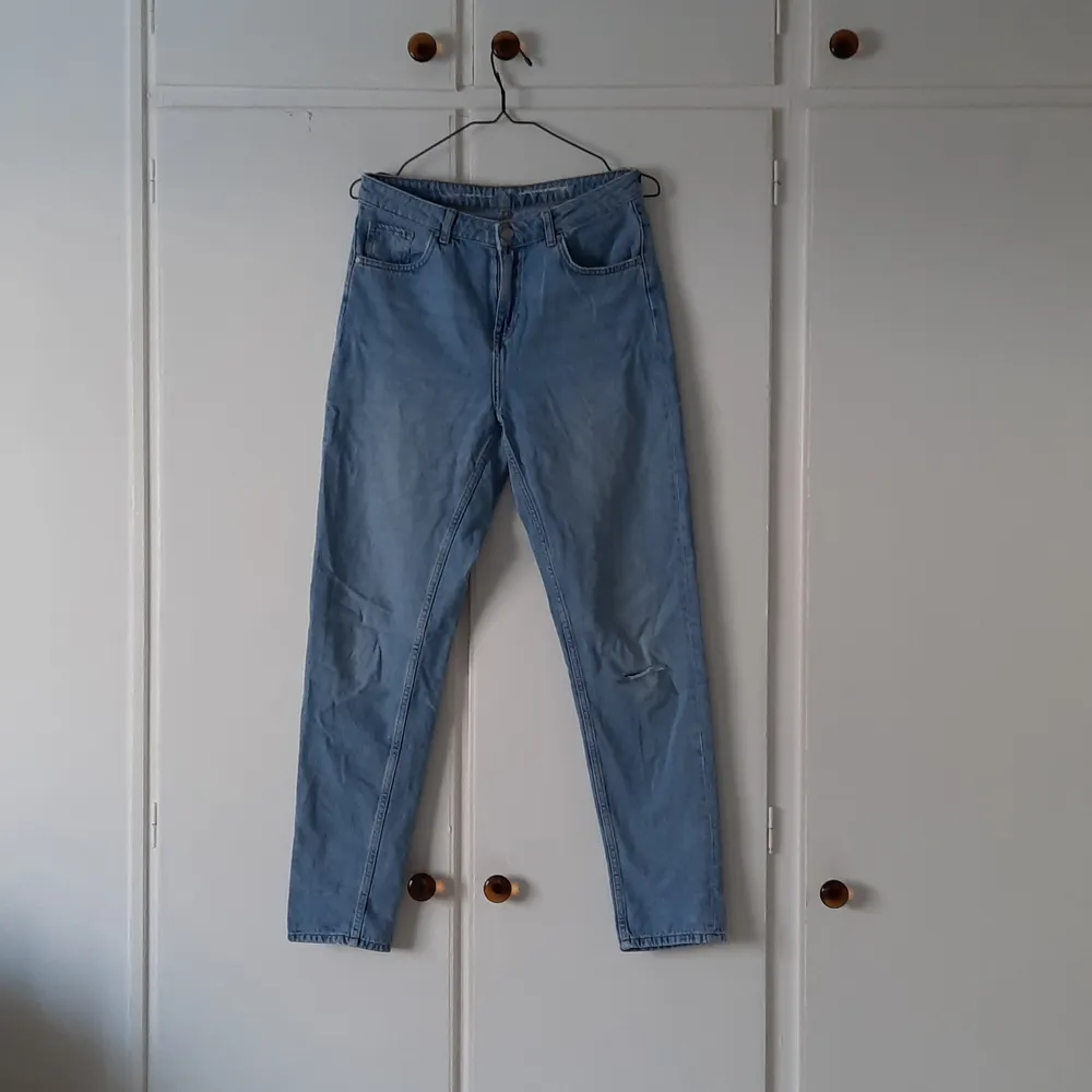 Ett par blå jeans, Never Denim, i storlek M. Det är en design med hål på vänster knä. Byxan smalnar av vid ankeln. Använda men i fint skicka, fick dem men aldrig själv använt dem så säljer. Pris: 80 + frakt. Jeans & Byxor.