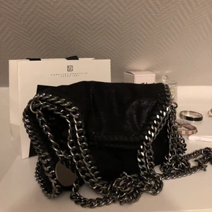 Stella McCartney liknande väska - En såå fin svart skimrig Stella McCartney liknande väska! Det finns två olika längder på kedjan, det är mellan modellen 💓 BUDA!!! :) Köp direkt för 1500!(BUDEN SKA HÖJAS MED 20kr, ANNARS GILLS DE EJ) ❗️FRAKT INGÅR EJ❗️!BUD ÄR BINDANDE!