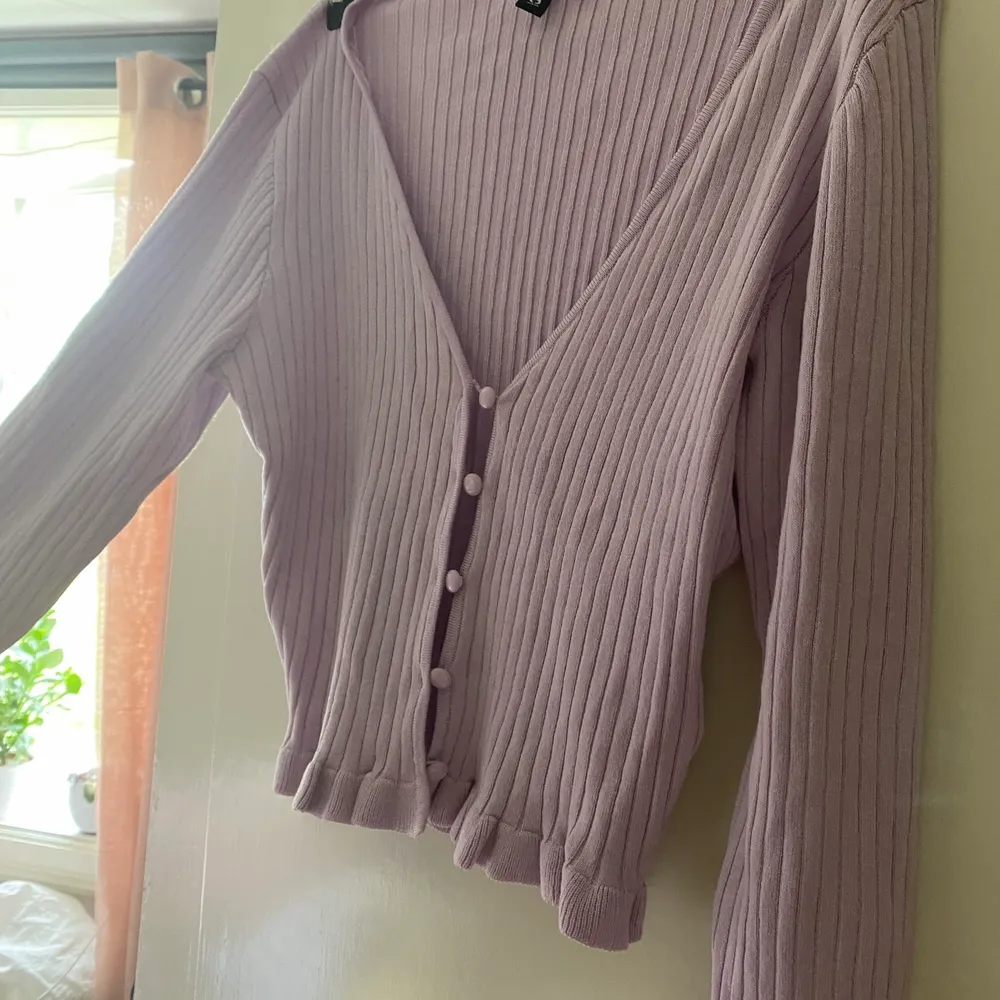 En söt rosalila knapptopp med volanger längs ärmarna och slutet på tröjan. Helt oanvänd, köpt från H&M💓. Toppar.