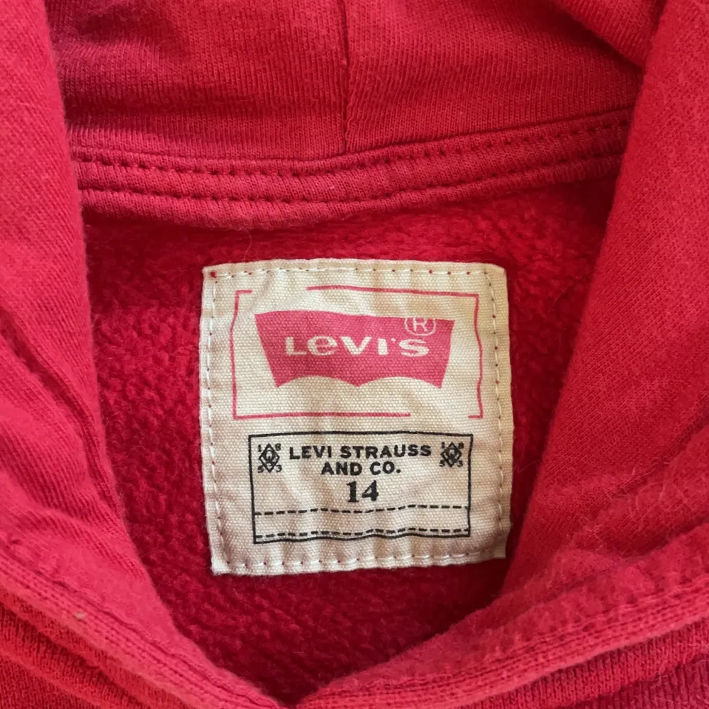 Snygg röd äkta Levi’s hoodie i storlek 14 (där storleken är i ålder, så 14 år) men skulle säga att den är i storlek S eftersom den är liten i storleken😁. Suuuper mjuk och skön och använd bara fåtal gånger. Köparen står för frakten!!. Hoodies.