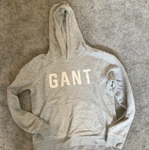 Gant hoodie storlek 158/164 - En grå fin gant hoodie med vitt stort tryck. Ganska basis o fin men fram för allt tunn för sommarkvällar. Är i storleken 158/164 o passar killar runt 13-14 år.