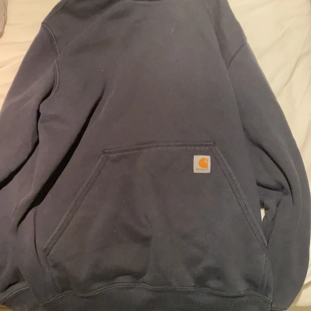 Carhartt hoodie som passar till allt med ett snyggt märke vid magfickan på tröjan. Hoodies.