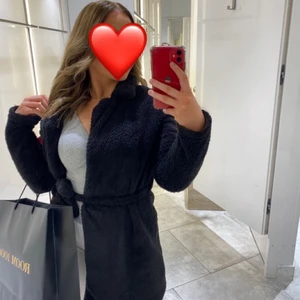 Fluffig kappa - Säljer denna svarta kappa i storlek S. Den har ett band vid midjan där man kan knyta hur man vill 🥰