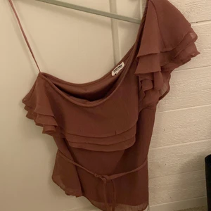 one shoulder topp - one shoulder topp från bubbelroom med ett midjeband använd få gånger, säljer pga för stor (pris 120 inklusive frakt) köpt för 399kr