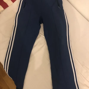 Adidas track pants  - ❗️GARDEROBSRENSNING❗️Säljer dessa tvär feta adidasbyxorna från 80 talet😍 Säljer pga att dom är lite för stora och jag behöver pengar. Hade inte sålt dom annars! Lite söndrga längre ner på byxan. Men du får skriva i pm om du är intresserad. Har tracktoppen också, kan sälja som ett paket. Men det kostar givetvis mer om du vill ha toppen.