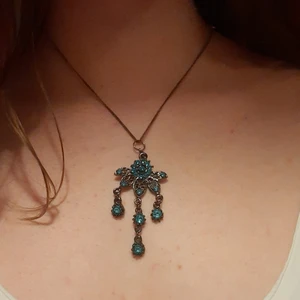 Halsband med blå blomma - Tvinnad läderrem medföljer.