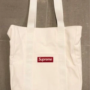 Supreme Totebag - Supreme - Canvas Tote. Äkta Supreme. Vit canvas totebag, helt ny och oanvänd. Digitalt kvitto finns. 1 300 kr (önskas frakt + 110 kr)