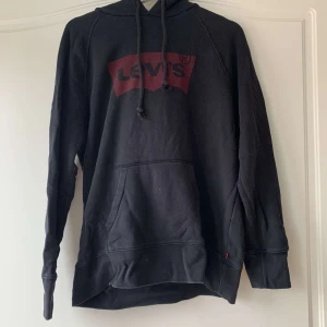 Levis hoodie - En fin svart hoodie från Levis i använt skick men fortfarande bra. Rött levistryck över bröstet. Storlek S men herrstorlek så den blir lite oversized och lång på mig som vanligtvis har S men supermysig. Säljs pga att den inte används längre💕💕