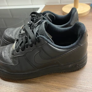 Svarta Nike air force  - Säljer mina svarta Nike, använda men i fint skick! Obs! Avskavt material inuti skon vid hälen.